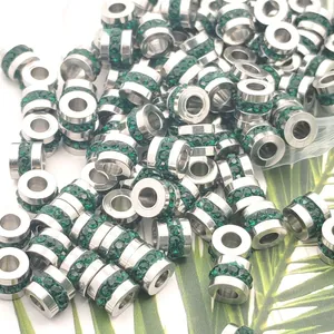 Gros plan de perles d'espacement en acier inoxydable avec strass verts pour bijoux DIY.