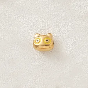 Close-up of a gold-plated stainless steel cartoon animal bead with yellow enamel eyes