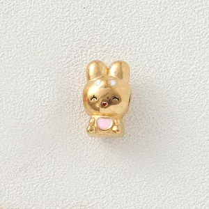 Macro view of golden stainless steel rabbit bead charm with pink heart enamel detail