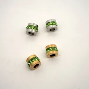 Detailed view of 18K gold and silver stainless steel wheel beads with green zircon stones.