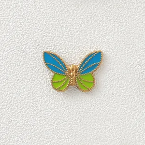 Detailed macro view of 18K gold plated butterfly bead with blue and green enamel
