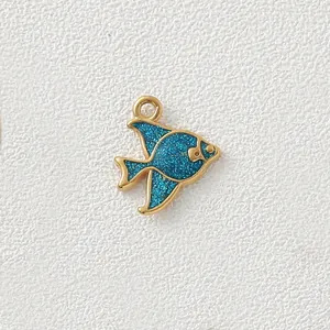 Close-up of golden tropical fish pendant with blue glitter for DIY jewelry accessory