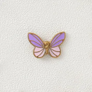 Close-up of the gold-plated butterfly charm featuring purple and pink gradient enamel