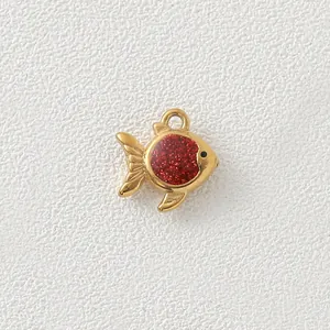 Macro view showing the fine texture and red glitter enamel of the gold fish charm.