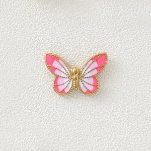 Macro detail of a 18K gold plated pink gradient butterfly charm for DIY jewelry