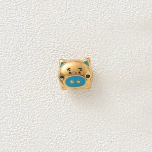 Macro detail view of a gold-plated stainless steel pig charm bead with blue enamel snout