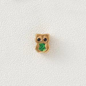 Detailed view of golden owl bead with green enamel belly for DIY jewelry design