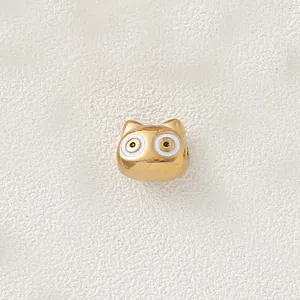 Macro detail of a gold-plated cartoon animal bead featuring white enamel eye accents.