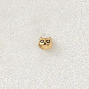 Macro view of a gold-plated stainless steel cartoon raccoon bead for DIY jewelry making