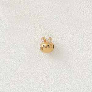 Close-up detail of gold plated stainless steel cartoon rabbit charm bead with enamel