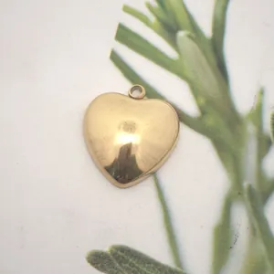 Macro view of polished gold heart-shaped stainless steel pendant for DIY jewelry