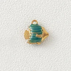 Macro view of a gold-plated fish pendant with green enamel stripes for DIY jewelry