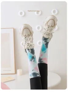 Nahaufnahme von bunten Tie-Dye Yoga-Socken mit beigen klobigen Turnschuhen kombiniert
