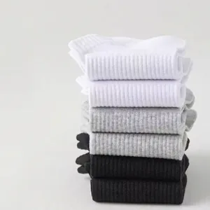 Close-up of stacked breathable cotton short socks for men in white, grey and black colors