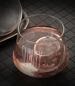 Close-up of a 304 stainless steel mesh tea infuser ball inside a clear glass cup