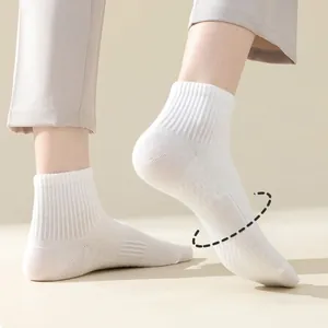 Detail shot of breathable white crew socks showing ribbed texture and mesh ventilation design