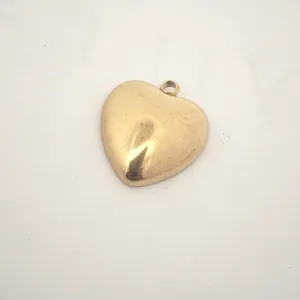 Macro view of a polished golden heart-shaped stainless steel charm for DIY jewelry making