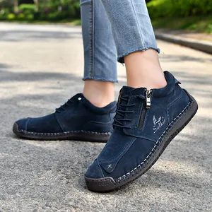 Detailed view of navy blue suede hand-stitched casual boots with side zipper and flat sole