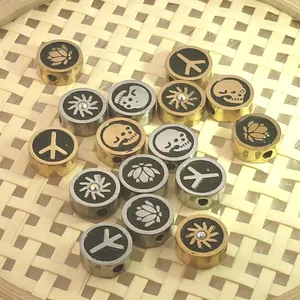 Detailed shot of stainless steel beads with lotus and skull patterns for DIY jewelry making.