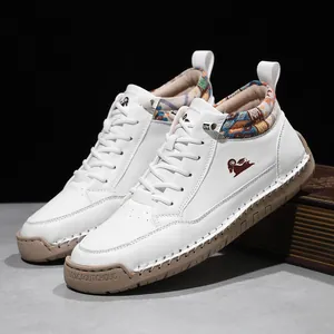 White mid-top Martin boots with hand-stitched detailing and vintage book prop view.