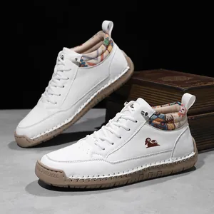 Detailed close-up of white mid-top casual boots with decorative hand-stitched rubber soles