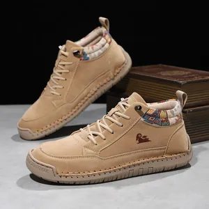 Close-up of tan mid-top outdoor leisure shoes with stitched rubber soles and woven trim.