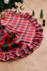 Detail view of a red and blue plaid Christmas tree skirt with ruffle edge decoration.