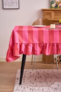 Primer plano de un mantel de algodón y lino a rayas rosas y rojas con elegantes volantes