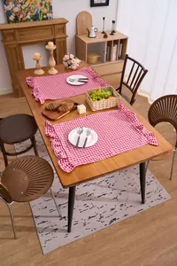 Red and white gingham hand towel with ruffled edges used as a rustic table placemat.