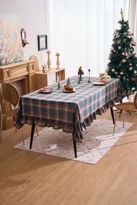Festive Christmas red and green plaid tablecloth with ruffle edges in a cozy room.