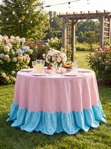 Vista esterna dettagliata della tovaglia a quadretti rosa con balza azzurra nel giardino verde