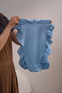Detailopname van een lichtblauwe katoenen placemat met elegante ruches aan de rand