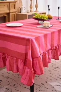 Primer plano de mantel de algodón y lino a rayas rosas con detalle de borde de volantes.