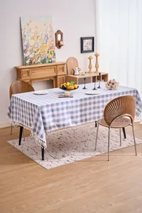Detailed view of a blue and white checkered cotton linen tablecloth with white tassels