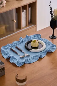 Blauwe gerimpelde katoenen placemat op een houten eettafel in een gezellige sfeer.