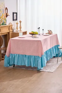 Tovaglia a quadretti rosa con bordo a balze blu mostrata in una sala da pranzo