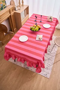 Mantel a rayas rosa y rojo de algodón y lino con borde de volantes en mesa de comedor