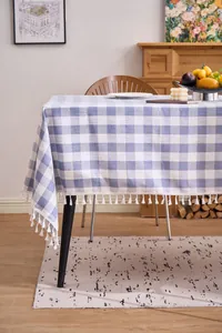Detail of blue and white checkered cotton linen tablecloth with elegant white tassels