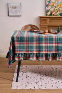 Detail of Christmas green and red plaid tablecloth with elegant ruffled edge design