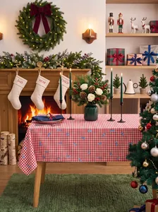 Details of a red gingham Christmas tablecloth with blue bows in a festive dining room