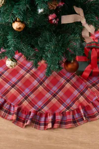 Detail shot of red plaid Christmas tree skirt with festive ruffle edge decoration.