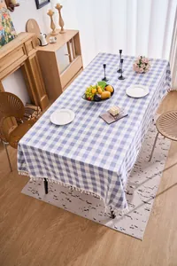 Blue and white checkered cotton linen tablecloth with tassel trim in a dining room