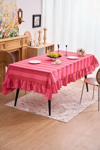 Vista detallada del mantel de algodón y lino a rayas rosas con elegante borde de volantes