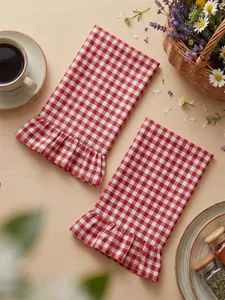 Detailed macro view of red and white gingham hand towels with ruffled edges.
