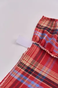 Close-up view showing the high-quality stitching and red plaid fabric of the tree skirt