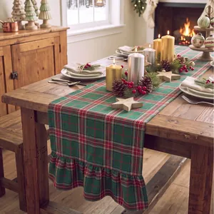 Rustic Christmas plaid table runner with ruffled edges displayed on a festive wooden dining table