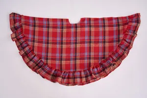 Detailed view showing the texture and ruffled edges of red plaid Christmas tree skirt