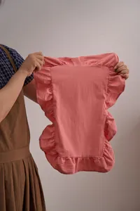 Detailweergave van de textuur en ruche-randen van een roze katoenlinnen placemat