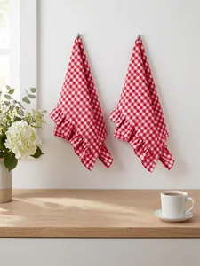Macro view of red and white checkered hand towels with elegant ruffled edges on white wall