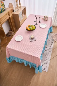 Vista dettagliata della tovaglia a quadretti rosa con elegante orlo a balze blu decorativo.